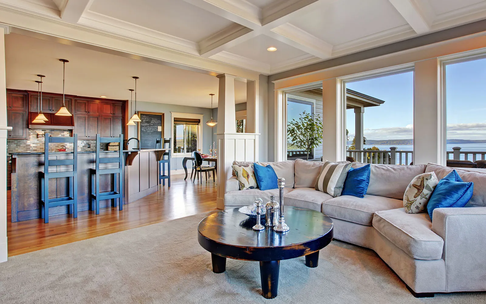 Open-plan living room and kitchen with water views through a wall of windows