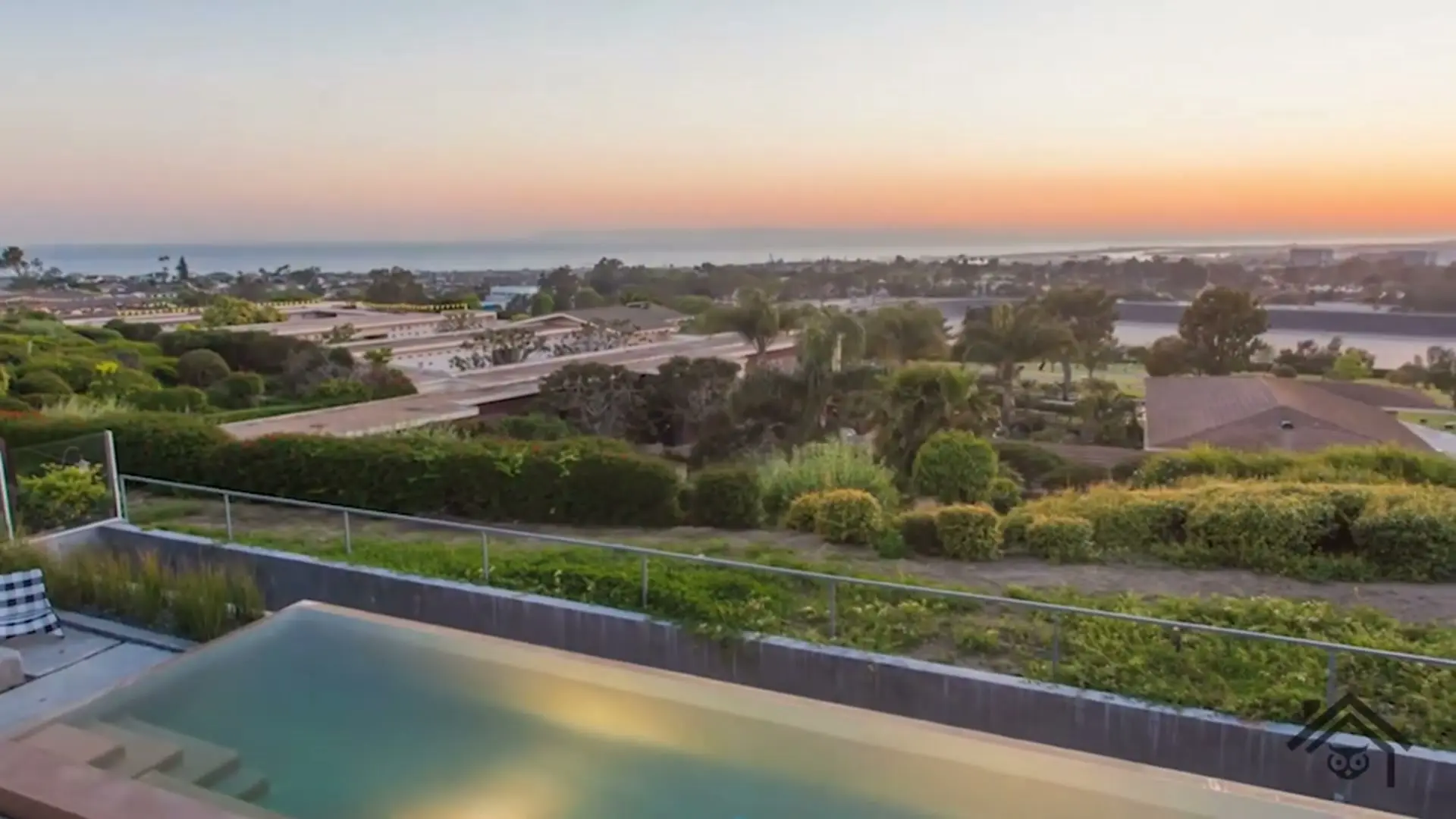 A pool terrace at sunset looking out over a South Orange County neighborhood to the ocean